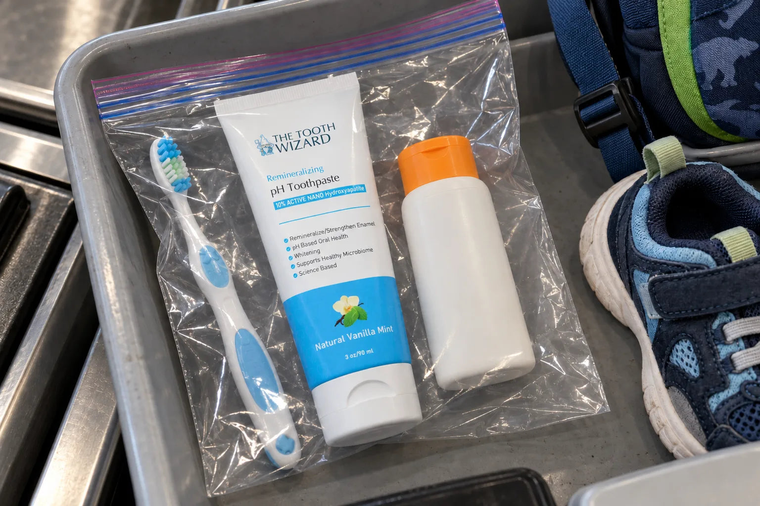 A Tooth Wizard tube in a clear bag in an airport security tray